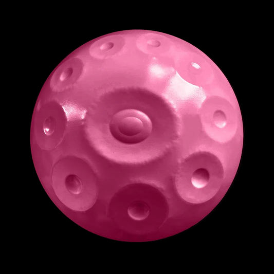 a pink ball with holes in it on a black background